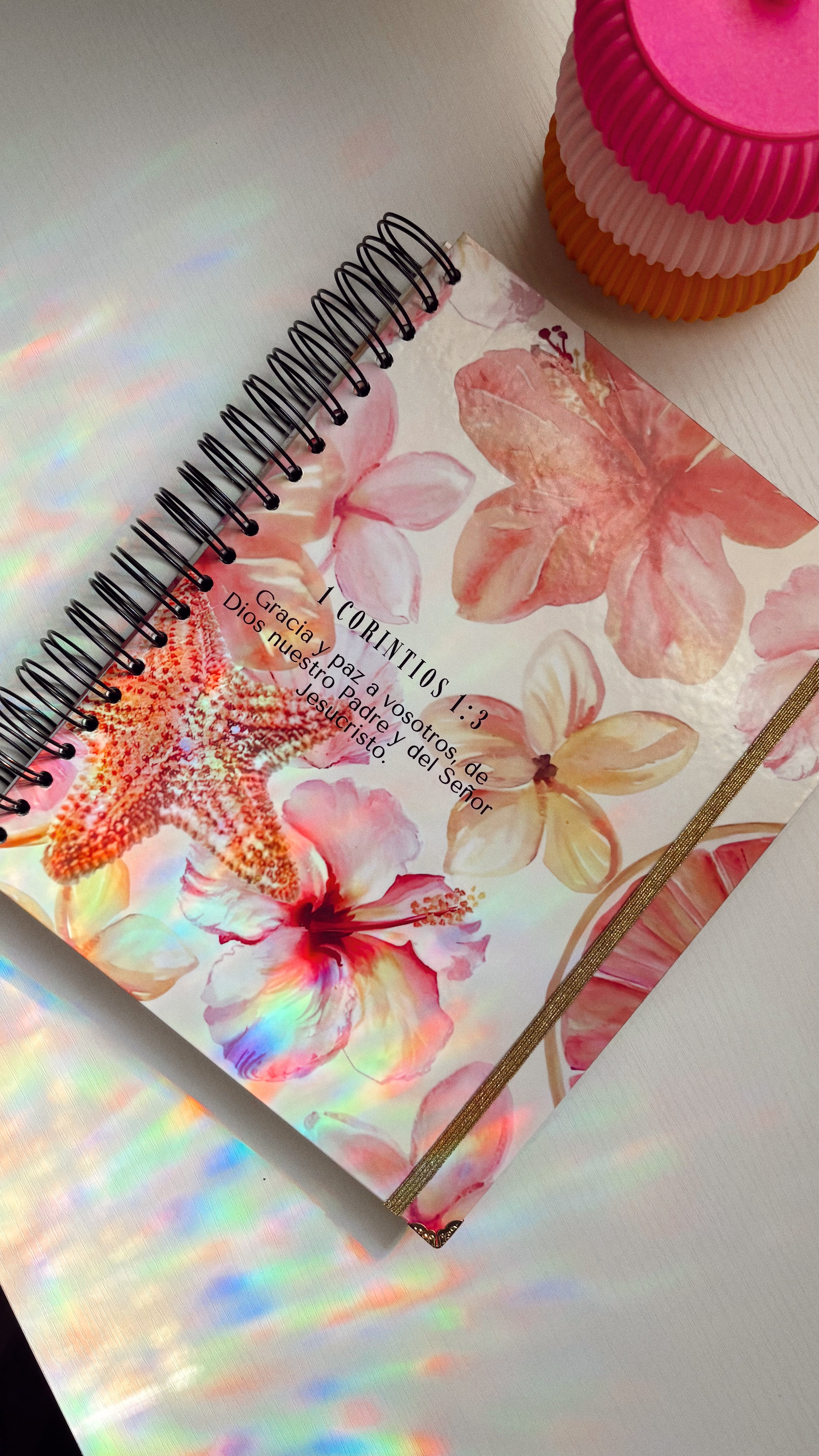 Floral notebook with a pink lid on a white surface